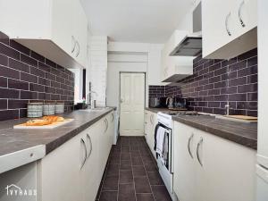 a large kitchen with white appliances and black tiles at BIRMINGHAM HOME : STYLISH : WELCOMES ALL in Birmingham