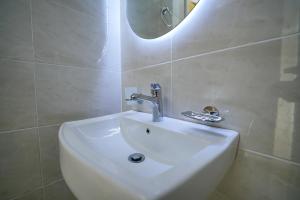 a white sink in a bathroom with a mirror at simple street apartment in Wadi Musa