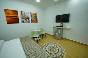 simple street apartment في وادي موسى: غرفة معيشة فيها تلفزيون وطاولة وكراسي