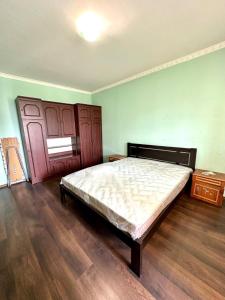 1 dormitorio con 1 cama y suelo de madera en Room Alfirdauas, en Targuist