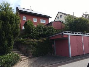 un garage rosso di fronte a una casa di Ferienwohnung Limper a Hilchenbach