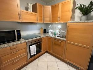 a kitchen with wooden cabinets and a sink and a microwave at Ferienwohnung Limper in Hilchenbach