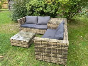 two wicker chairs and a couch in the grass at CASALINO DI ANNA 2 in Wensickendorf