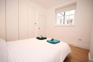 a bedroom with a white bed with two green towels on it at Lovely flat in Baker street in London