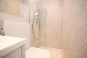 y baño con ducha, aseo y lavamanos. en Lovely flat in Baker street, en Londres