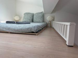 Un dormitorio con una cama y suelo de madera. en Appartement cosy au cœur de l’Écusson, en Montpellier