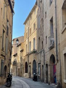 un callejón con dos motocicletas estacionadas junto a los edificios en Appartement cosy au cœur de l’Écusson, en Montpellier