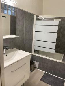 Un baño con un lavabo blanco y un espejo. en Appartement cosy au cœur de l’Écusson, en Montpellier