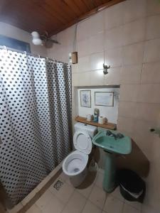 y baño con aseo, lavabo y ducha. en Como en casa Hostel en Posadas