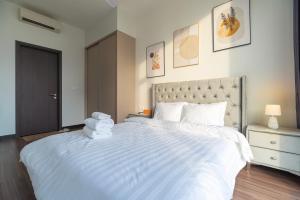 a bedroom with a large white bed with towels on it at Fully-Equipped Luxury Condo in Central Ho Chi Minh with Downtown and River View in Ho Chi Minh City