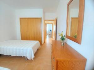 a bedroom with a bed and a dresser and a mirror at Desertrose in Porto Santo