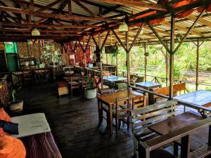a restaurant with wooden tables and chairs in a room at Hostel Plinio in Manuel Antonio