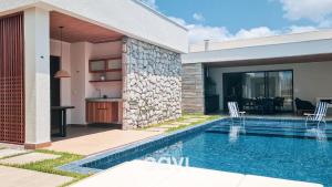 a house with a swimming pool next to a house at Villa Makani no Shamballa by Qavi in São Miguel do Gostoso