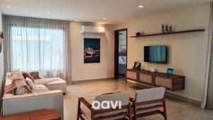 a living room with a couch and a tv at Villa Makani no Shamballa by Qavi in São Miguel do Gostoso