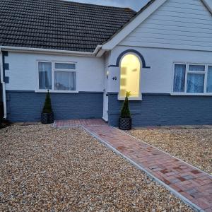 a house with a brick driveway in front of it at Stylish bungalow with complimentary breakfast on the first morning in Lancing