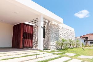 a building with a red door on the side of it at Villa Makani no Shamballa by Qavi in São Miguel do Gostoso