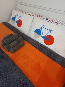 een bed met 2 kussens en een oranje tapijt bij Ferienwohnung Neli am Rhein in Rheinbrohl
