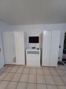 a room with white cabinets and a television on a table at Ferienwohnung Neli am Rhein in Rheinbrohl