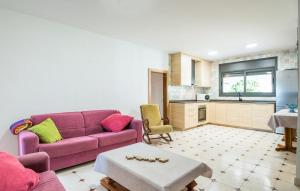 sala de estar con sofá púrpura y cocina en Casa Roda de Berà (Barà), en Roda de Bará