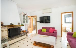 sala de estar con 2 sillas moradas y chimenea en Casa Roda de Berà (Barà), en Roda de Bará