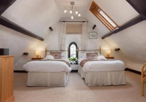 a bedroom with three beds and a window at Salty House Shaldon in Shaldon