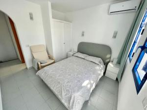 una piccola camera con letto e sedia di Bungalow playmar 24 a Maspalomas