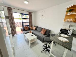 a living room with a couch and a table at Bungalow playmar 24 in Maspalomas