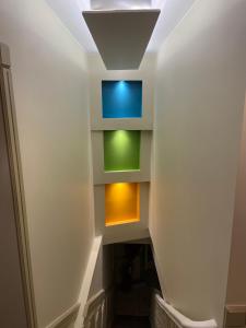 une cage d'escalier avec un mur aux lumières colorées dans l'établissement Résidence le Marcadieu, à Tarbes
