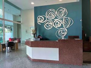 a reception desk in a lobby with a painting of roses at Praia do Canto Apart Hotel quarto sala e varanda in Vitória +15 photos