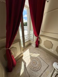 Cette chambre dispose d'une fenêtre avec des rideaux rouges. dans l'établissement Résidence le Marcadieu, à Tarbes