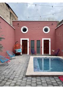 um edifício vermelho com uma piscina em frente em Quinta La Perla em Guadalajara