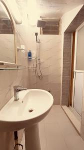 a white bathroom with a sink and a shower at Résidence d hôtes Minerva Mermoz in Dakar