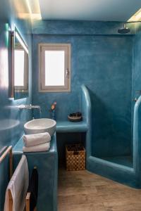 niebieska łazienka z wanną i umywalką w obiekcie Amelia Villa Collection w mieście Arkítsa