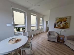 - un salon avec une table et des chaises blanches dans l'établissement Ferienwohnung Ida an der Flensburger Förde, à Flensbourg