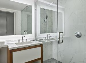 a white bathroom with two sinks and a shower at The Westin Pasadena in Pasadena