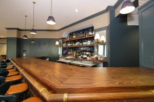 a large wooden bar in a restaurant with chairs at The Oliver, Oxford in Oxford
