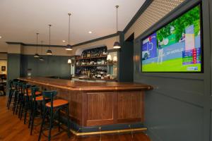 a bar with a flat screen tv in a restaurant at The Oliver, Oxford in Oxford