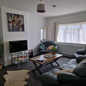 a living room with a couch and a coffee table at Stylish bungalow with complimentary breakfast on the first morning in Lancing