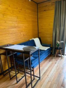 Zimmer mit einem blauen Sofa, einem Tisch und einer Bank in der Unterkunft Cabana Canela in Urubici
