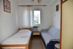 Habitación pequeña con 2 camas y ventana en Apartments in Supetar - Insel Brac 31170, en Supetar