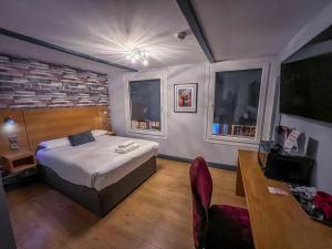 um quarto com uma cama, uma secretária e 2 janelas em Twenty Hotel and Bar em Boston