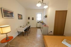 a room with a bed and a table and a kitchen at Affittacamere Donati Nada in Carmignano