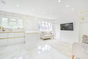 a white kitchen with a sink and a tv at PREMIUM Private Apartment minutes to Central London in London