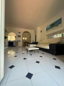 uma ampla sala de estar com uma cama e piso em azulejo em VILLABRI em Maratea