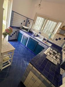 a kitchen with blue tiled floors and blue cabinets at VILLABRI in Maratea