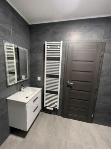 a bathroom with a white sink and a mirror at Penzion Fortuna Žatec in Žatec