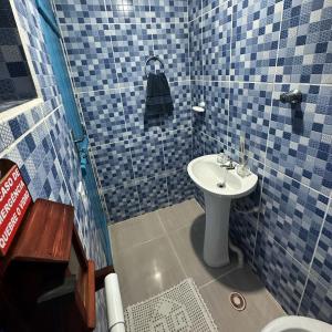 een blauwe betegelde badkamer met een wastafel en een douche bij Recanto São Francisco in Campos do Jordão