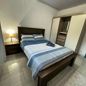a bedroom with a bed with a blue blanket at Recanto São Francisco in Campos do Jordão
