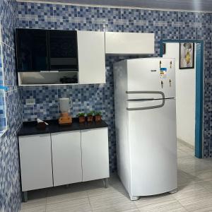 a kitchen with white cabinets and a refrigerator at Recanto São Francisco in Campos do Jordão