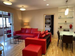 uma sala de estar com um sofá vermelho e uma mesa em Proper Apartment 2 em Tirana